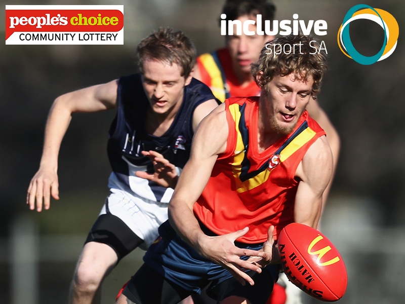 A South Australian State Football Player is running for the football a Victorian Player is close behind chasing him. Inclusive Sport SA logo and People's Choice Credit Union Community Lottery logos appear at top of image