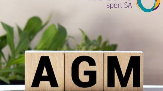 Blocks sit on a table and spell AGM. There is a plant in the background and the Inclusive Sport SA logo appears in the top right hand corner.